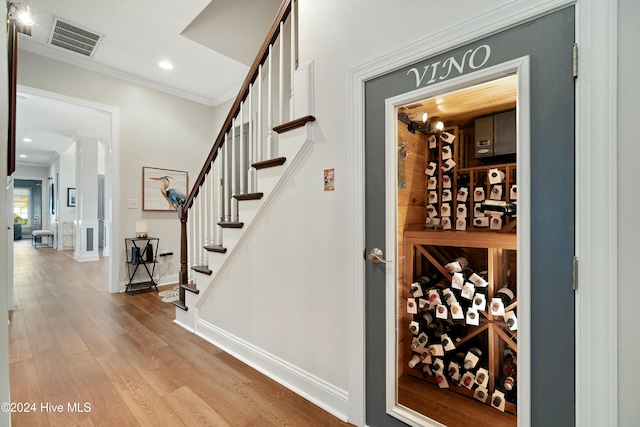 wine room featuring crown molding and light hardwood / wood-style flooring