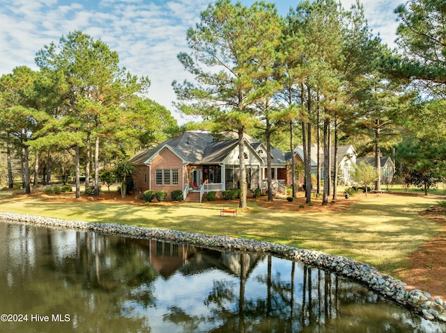 back of property featuring a water view and a yard