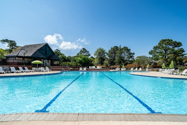 community pool with a patio area and fence