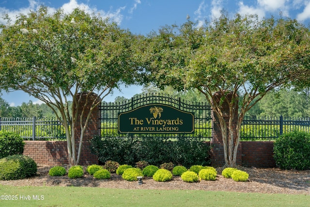 community / neighborhood sign featuring fence