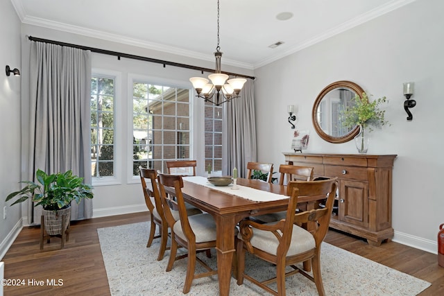 dining room with dark hardwood / wood-style floors, an inviting chandelier, and ornamental molding