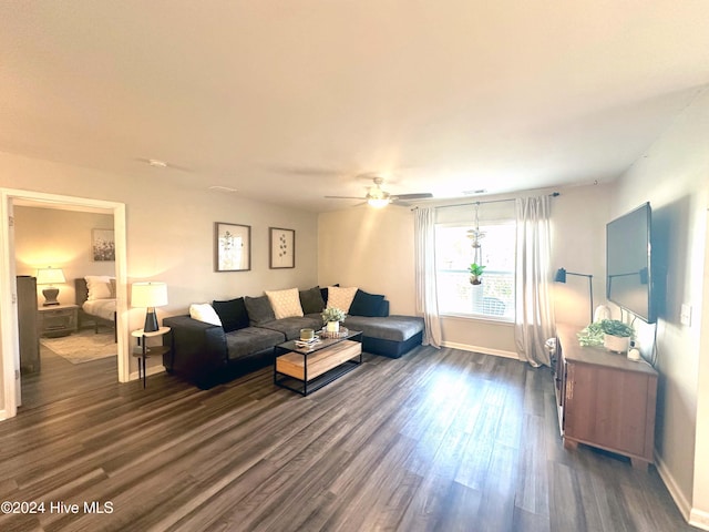 living room with ceiling fan and dark wood-type flooring