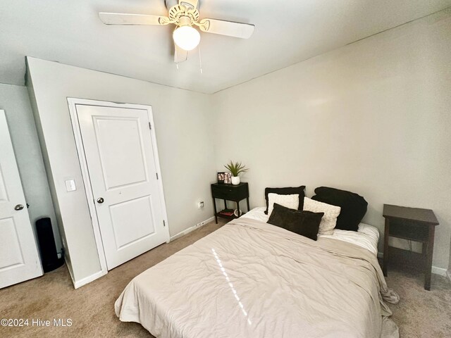 carpeted bedroom with ceiling fan and a closet