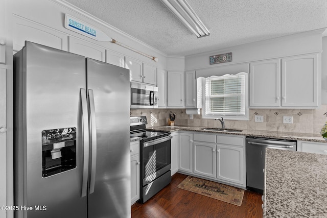 kitchen with a textured ceiling, dark hardwood / wood-style floors, white cabinetry, appliances with stainless steel finishes, and sink