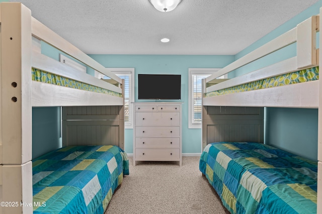 bedroom with light colored carpet and a textured ceiling