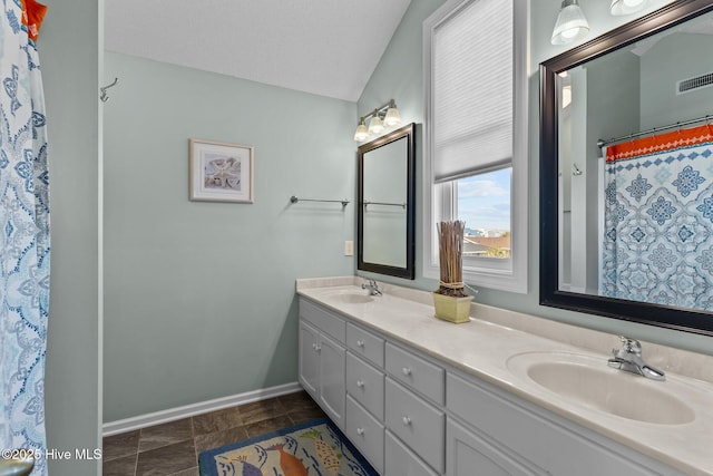 bathroom featuring a textured ceiling, vaulted ceiling, vanity, and curtained shower