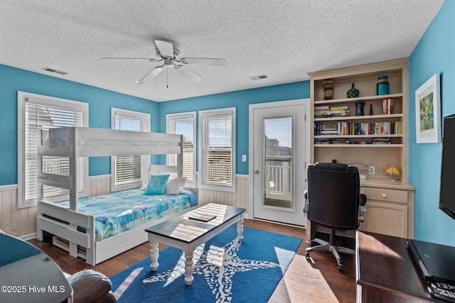 bedroom with ceiling fan, access to outside, multiple windows, and dark hardwood / wood-style floors