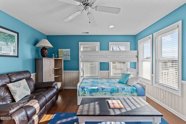 bedroom featuring a textured ceiling, ceiling fan, and dark hardwood / wood-style floors