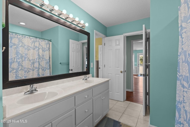 bathroom with vanity, tile patterned floors, and a textured ceiling