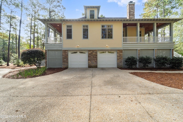 view of front of property with a garage, a chimney, concrete driveway, and brick siding