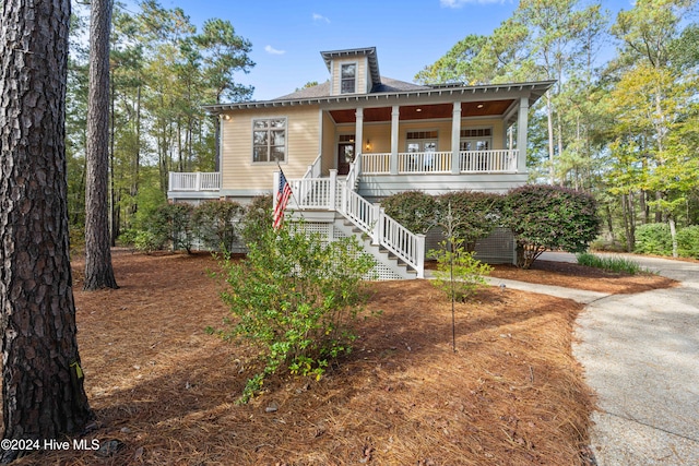 view of front of property featuring stairway and a porch