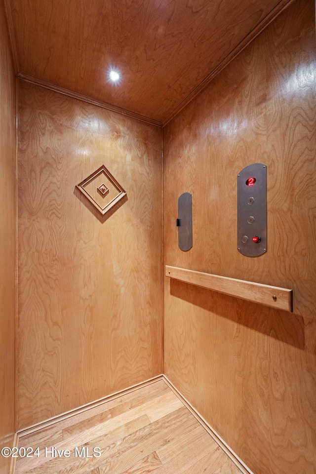 interior details featuring wood ceiling, elevator, recessed lighting, and wood finished floors