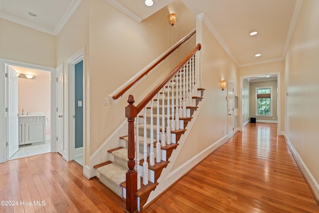 stairs with wood-type flooring, crown molding, and baseboards