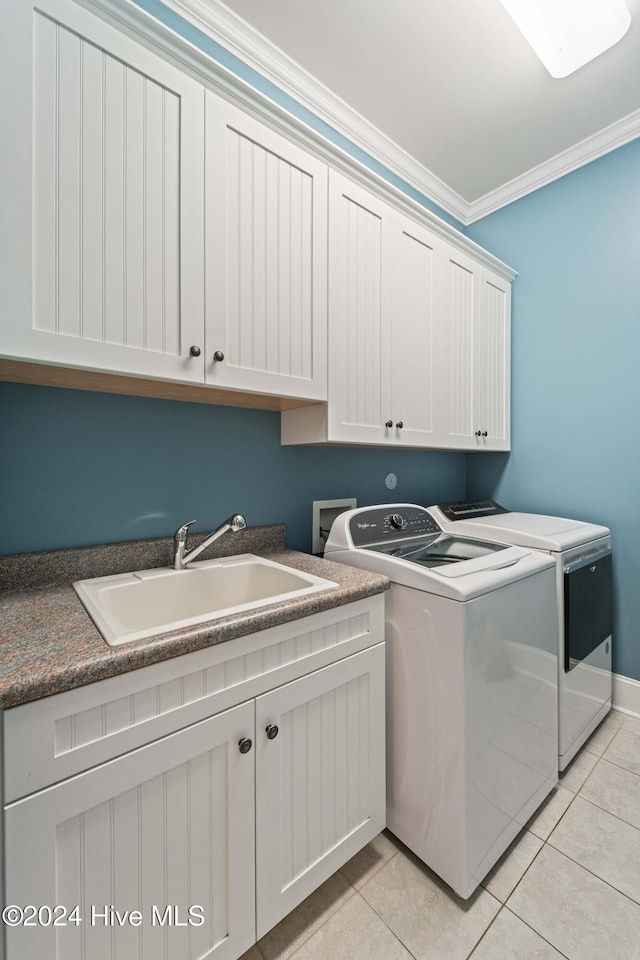 laundry area with cabinet space, light tile patterned floors, crown molding, separate washer and dryer, and a sink