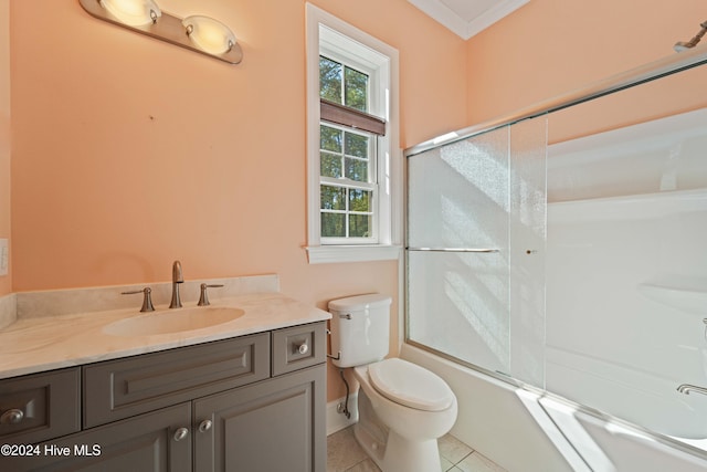 bathroom with tile patterned flooring, toilet, vanity, ornamental molding, and combined bath / shower with glass door