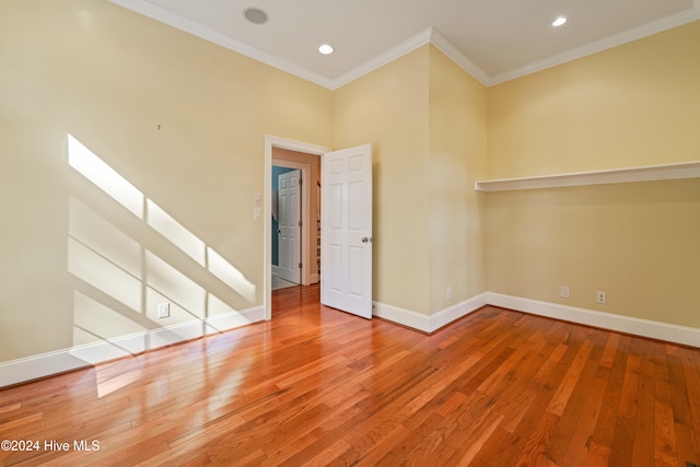 spare room featuring ornamental molding, wood-type flooring, recessed lighting, and baseboards