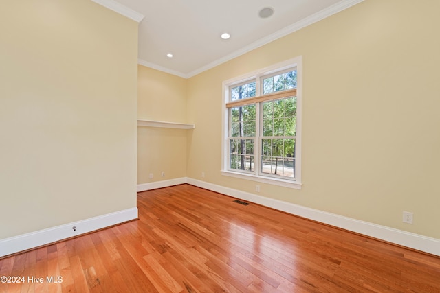 unfurnished room featuring recessed lighting, wood finished floors, visible vents, baseboards, and ornamental molding