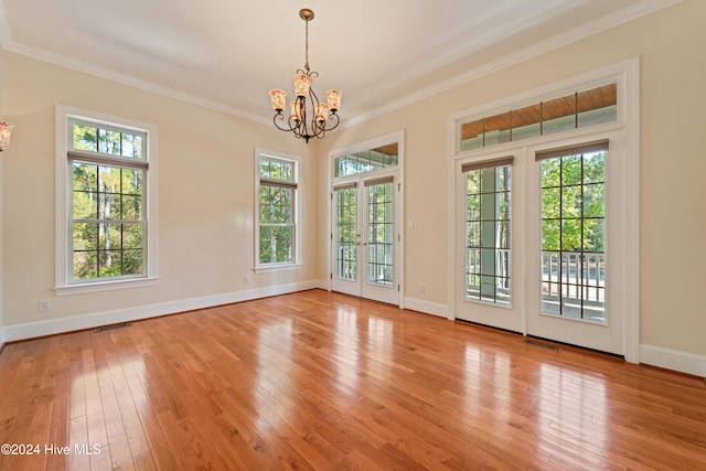 interior space with a chandelier, a healthy amount of sunlight, visible vents, and light wood-style floors