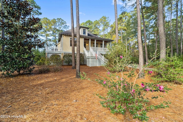 view of front of property featuring covered porch and stairs