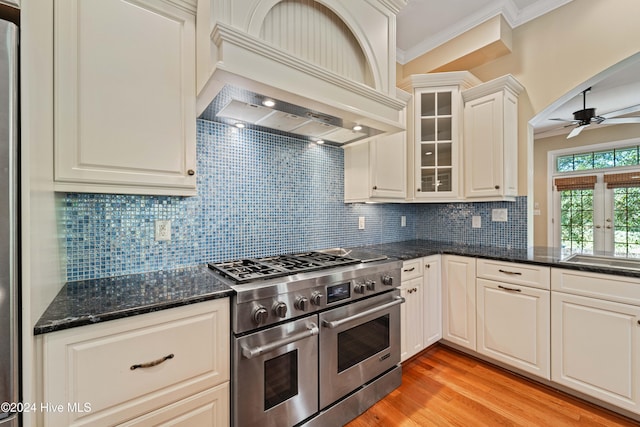 kitchen with light wood-style flooring, premium range hood, a ceiling fan, ornamental molding, and double oven range