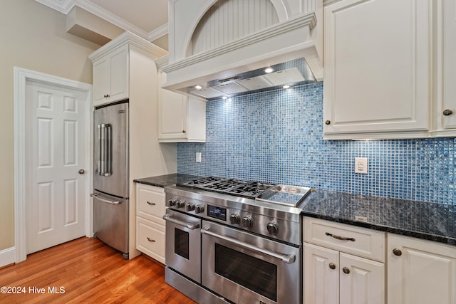 kitchen featuring high end appliances, light wood-style flooring, custom exhaust hood, crown molding, and white cabinetry