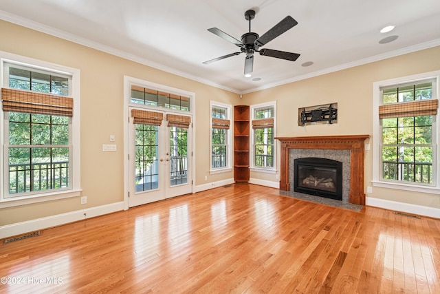 unfurnished living room with a high end fireplace, light wood-style flooring, and crown molding