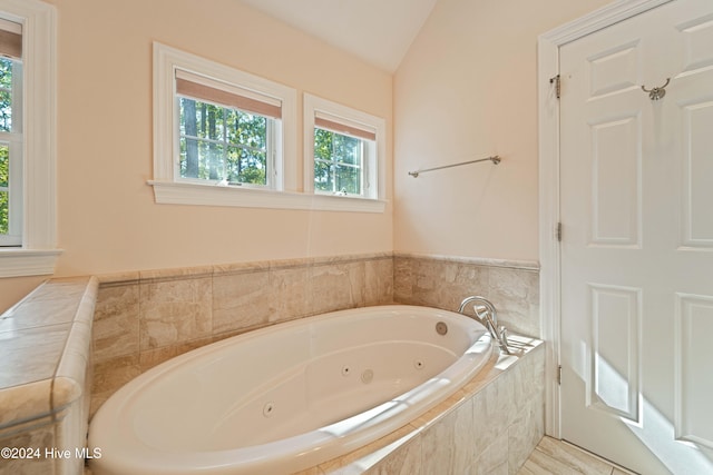 full bath featuring vaulted ceiling and a jetted tub