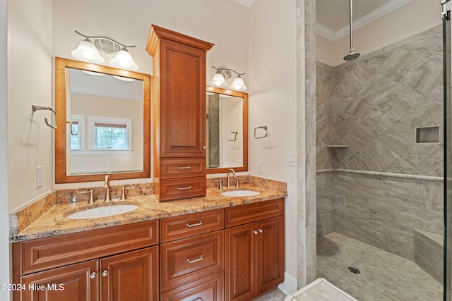 bathroom featuring ornamental molding, a sink, and a tile shower