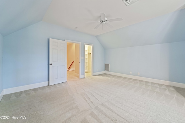 additional living space with light carpet, baseboards, and vaulted ceiling