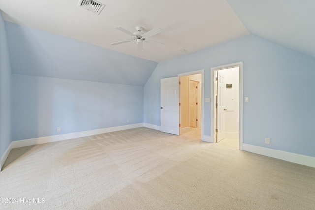 bonus room with lofted ceiling, light carpet, a ceiling fan, visible vents, and baseboards