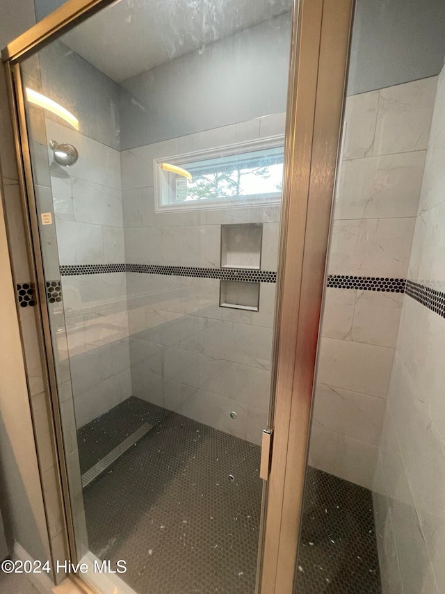 bathroom featuring a shower with shower door