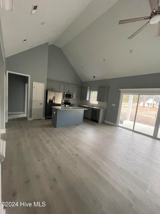 kitchen featuring light wood-type flooring, gray cabinets, stainless steel appliances, and a kitchen island