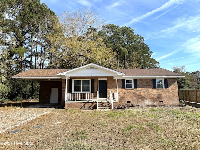 ranch-style house featuring covered porch and a carport