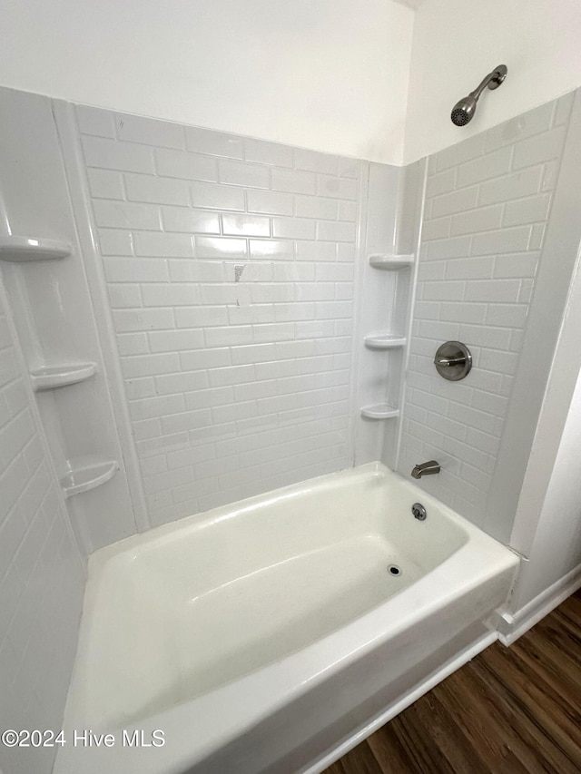 bathroom with hardwood / wood-style flooring and tiled shower / bath combo