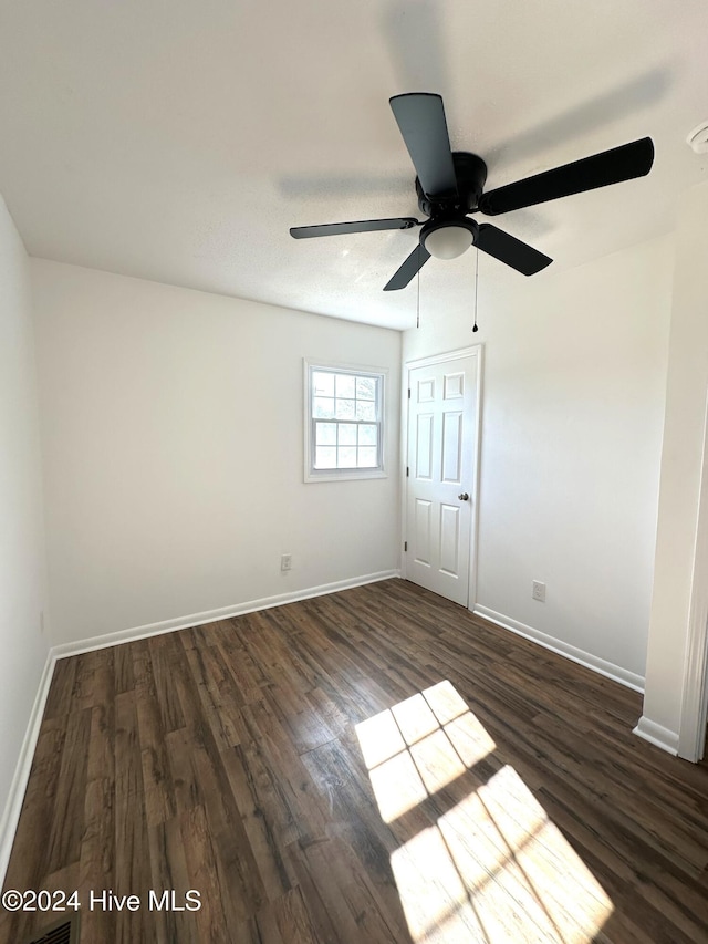 unfurnished room featuring ceiling fan and dark wood-type flooring