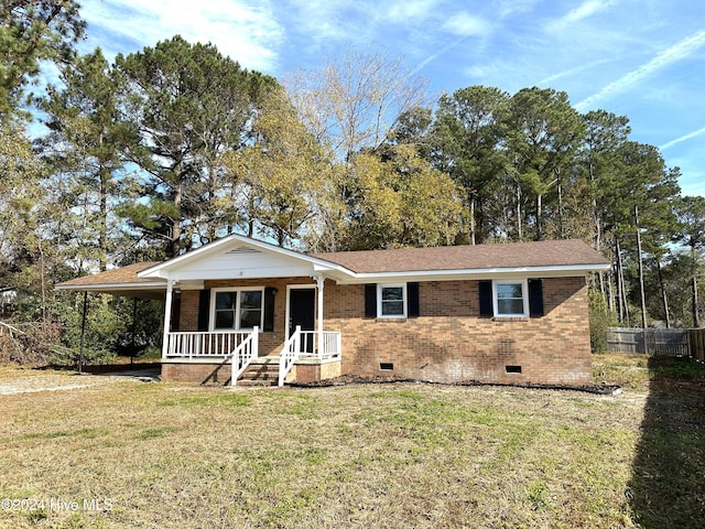 ranch-style home featuring covered porch and a front lawn