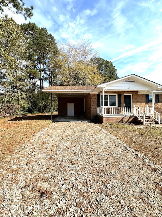 view of front of home with a porch and a carport