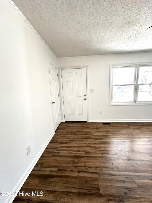 interior space with a textured ceiling and dark hardwood / wood-style floors