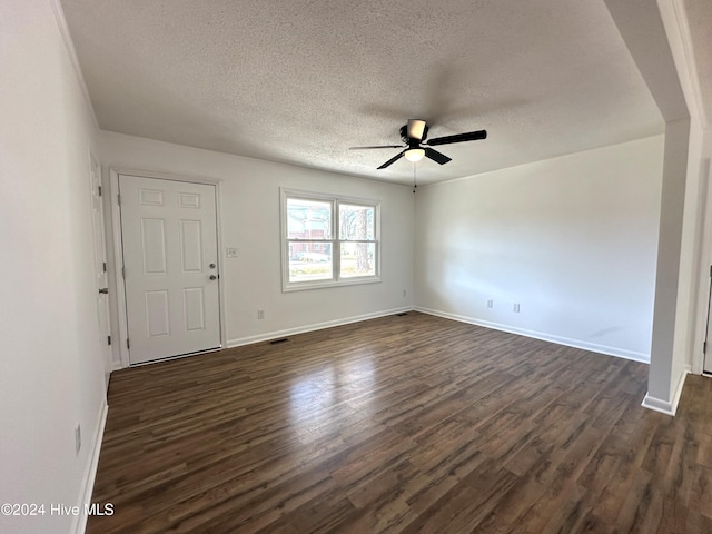 unfurnished room with a textured ceiling, ceiling fan, and dark wood-type flooring