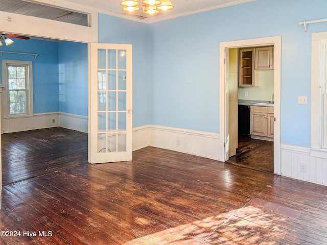 spare room featuring dark wood-type flooring, french doors, ceiling fan with notable chandelier, sink, and crown molding