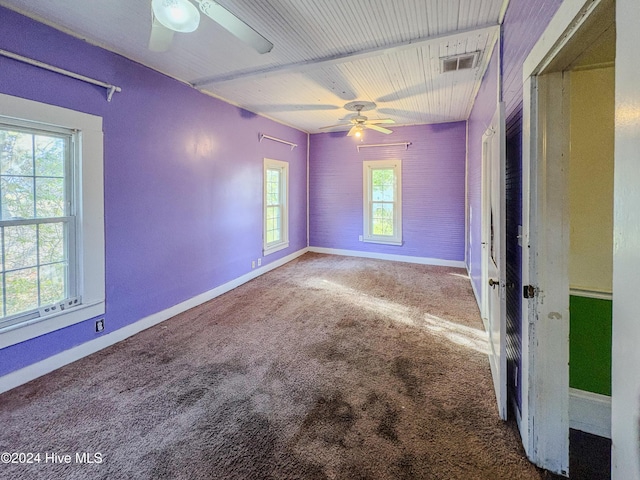 unfurnished bedroom featuring multiple windows, ceiling fan, and carpet floors