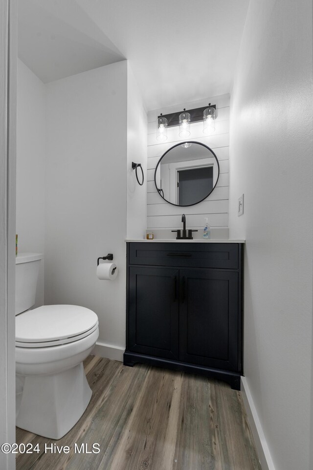 bathroom with hardwood / wood-style floors, vanity, and toilet