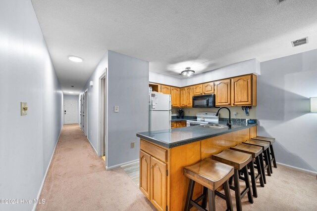 kitchen with light wood-type flooring, stainless steel dishwasher, sink, white electric stove, and lofted ceiling