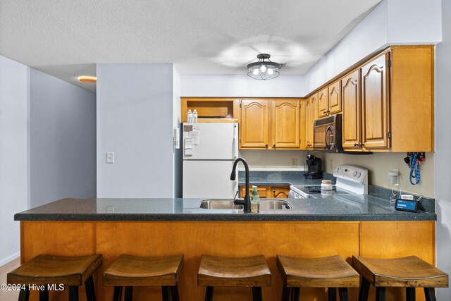 kitchen featuring sink, kitchen peninsula, stainless steel dishwasher, ceiling fan, and carpet floors