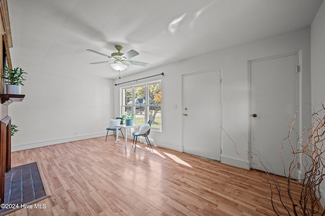 entrance foyer with ceiling fan, light hardwood / wood-style floors, and a fireplace