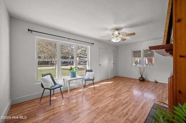 living area with light wood-type flooring and ceiling fan