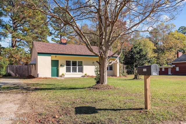 ranch-style house with a front yard and a storage shed