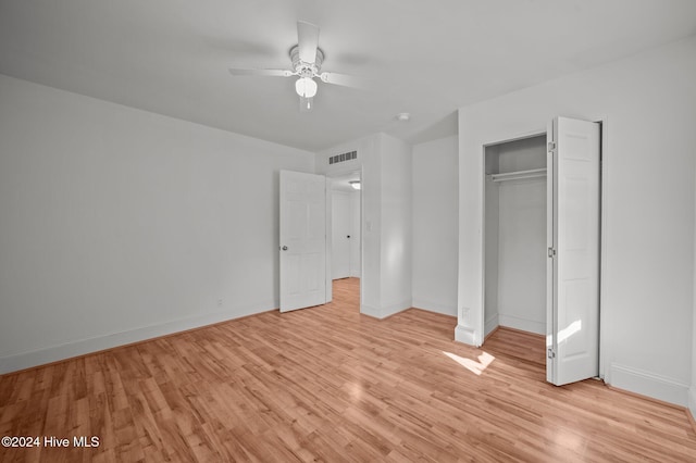 unfurnished bedroom featuring ceiling fan, light hardwood / wood-style flooring, and a closet