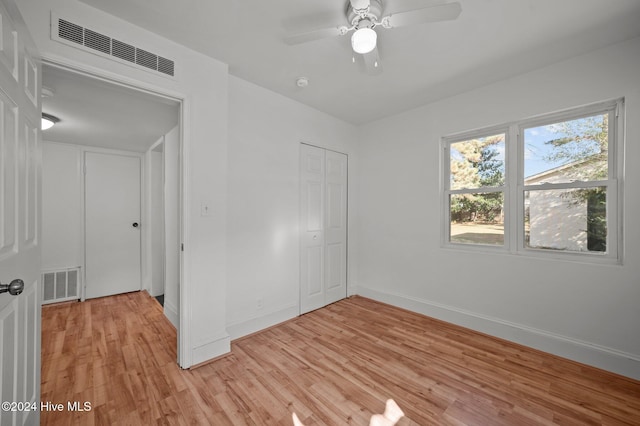 unfurnished bedroom featuring a closet, ceiling fan, and light wood-type flooring