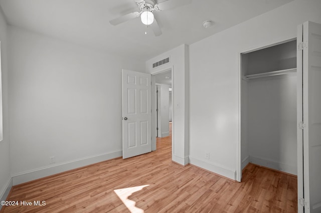 unfurnished bedroom with ceiling fan, a closet, and light wood-type flooring